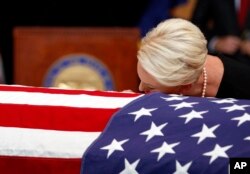 Cindy McCain, esposa del senador John McCain, apoya la cabeza sobre el ataúd durante el servicio recordatorio en Phoenix, Arizona, el miércoles, 29 de agosto de 2018.