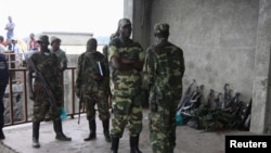 M23 rebels guard weapons given to them by the government's army in Goma November 21, 2012. 