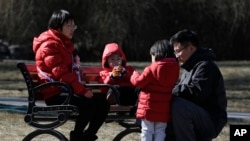 Sepasang suami-istri sedang bersantai di taman bersama anak-anak mereka, di Beijing, China, 17 Feb 2019.