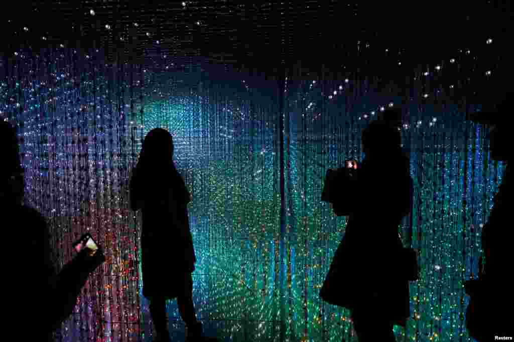 Visitors look at a digital installation which is a part of &quot;Dance! Art Exhibition, Learn &amp; Play!&quot; by Japanese group teamLab in Taipei, Taiwan.