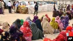 Internally displaced Somali women queue to receive food-aid rations at a distribution center