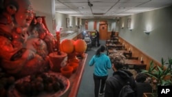 A Buddhist prayer shrine sits on a shelf over-looking a near empty Vegetarian Dim Sum restaurant in New York's ChinaTown, usually bustling with afternoon customers, Thursday Feb. 13, 2020, in New York. Chinatown has seen a decline in customers amid fears 