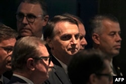 FILE - Brazil's President Jair Bolsonaro arrives at the inauguration ceremony of the new president of the Parliamentary Front of Agriculture (FPA), at the Clube Naval, in Brasilia, Jan. 19, 2019.