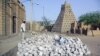 In this May 1, 2012 photo, men work alongside one of Timburktu's historic mud mosques in Mali. 