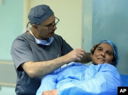Plastic surgeon Dr. Abbas al-Sahan makes surgical marks around the damaged ear of Saja Ahmed Saleem, before her reconstructive surgery in Baghdad, Iraq, Nov. 6, 2018. Saleem lost both eyes, right arm and ear and suffered disfigurement in a bomb explosion when she was 6 years old.