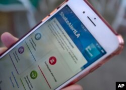 A mobile phone customer looks at an earthquake warning application on their phone in Los Angeles, Jan. 3, 2019. The app, called ShakeAlertLA, is available for download on Android and Apple phones.