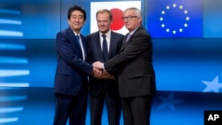 Predsednik Evropske komisije, Žan Klod Junker (desno), predsednik Evropskog saveta Donald Task (centar) i premijer Japana, Šinzo Abe, pozdravljaju se pre sastanka u zgradi Evropa u Briselu, 21. marta 2017.