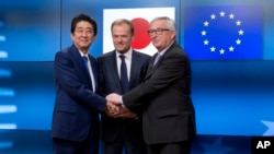 European Commission President Jean-Claude Juncker, right, European Council President Donald Tusk, center, greet Japanese Prime Minister Shinzo Abe prior to a meeting at the Europa building in Brussels on Tuesday, March 21, 2017.