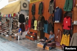 FILE - Shop vendors wait for customers in the Mediterranean resort city of Antalya, Turkey, June 3, 2016.