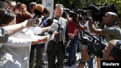 Greece's Finance Minister Yannis Stournaras is surrounded by the media as he leaves the Prime Minister's office in Athens, September 10, 2012.