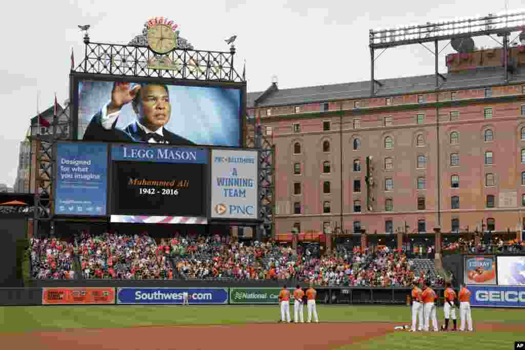 Members of the Baltimore Orioles stand on the field during a moment of silence for boxer Muhammad Ali before a baseball game against the New York Yankees in Baltimore, June 4, 2016.&nbsp;Ali died at age 74.