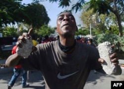 A demonstrator gestures during clashes in front of the National Palace, in the center of Haitian capital Port-au-Prince, Feb. 13, 2019.
