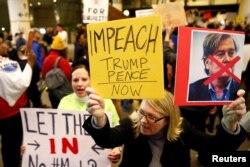 Seorang wanita memegang poster, mendorong pemakzulan Trump dan Pence selama protes larangan perjalanan Donald Trump dari negara-negara mayoritas muslim di Bandara Internasional Los Angeles (Foto: Reuters)