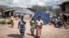 Des femmes déplacées par l'éruption du volcan Nyiragongo marchent dans la rue à Minova, à 50 kilomètres au sud de Goma, la capitale provinciale du Nord-Kivu, le 2 juin 2021.