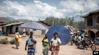 Des femmes déplacées par l'éruption du volcan Nyiragongo marchent dans la rue à Minova, à 50 kilomètres au sud de Goma, la capitale provinciale du Nord-Kivu, le 2 juin 2021.