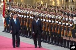Chinese President Xi Jinping, left, walks with Zimbabwe's President Robert Mugabe during a welcome ceremony outside the Great Hall of the People in Beijing, China, Aug. 25, 2014.