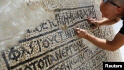 A conservationist works on a 1,500-year-old mosaic floor bearing Greek writing, discovered near Damascus Gate in Jerusalem's Old City, as it is displayed at the Rockefeller Museum in Jerusalem, Aug. 23, 2017.