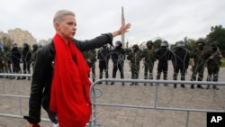 Lãnh đạo đối lập Belarus, Maria Kolesnikova, đi trước hàng rào cảnh sát chống bạo động trong cuộc biểu tình ngày 23/8/2020.