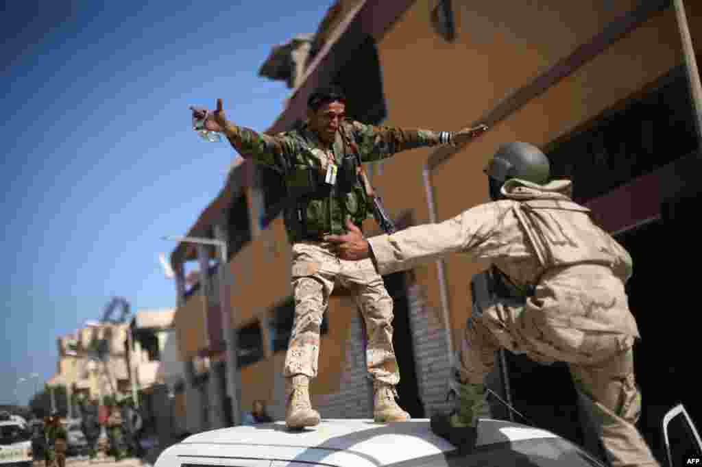 October 20: Revolutionary fighters celebrate the capture of Sirte, Libya. Moammar Gadhafi was killed Thursday when revolutionary forces overwhelmed his hometown, Sirte, the last major bastion of resistance two months after the regime fell. (AP Photo/Manu