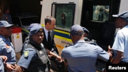 South African Olympic and Paralympic sprinter Oscar Pistorius, center, enters a police van after his sentencing at the North Gauteng High Court in Pretoria, Oct. 21, 2014. 