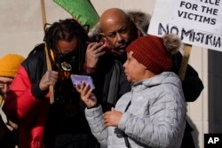 Justin Blake, left, uncle of Jacob Blake, listens to the verdict being read outside the Kenosha County Courthouse, Friday, Nov. 19, 2021 in Kenosha, Wis.