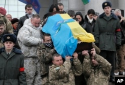 Ukrainian soldiers carry a coffin bearing the body of a fellow serviceman who was killed in fighting with pro-Russia rebels in eastern Ukraine, during his funeral in Kyiv Jan. 20, 2015.
