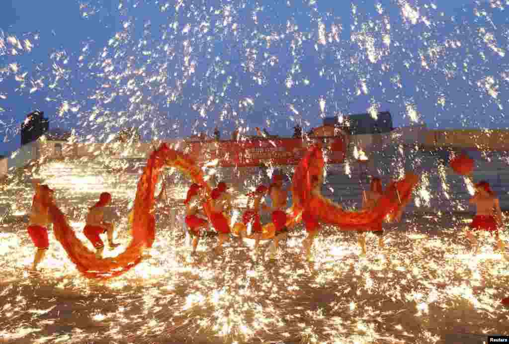 Dancers perform a fire dragon dance in the shower of molten iron spewing firework-like sparks during a folk art performance to celebrate the Chinese Lunar New Year at an amusement park in Beijing February 10, 2013.