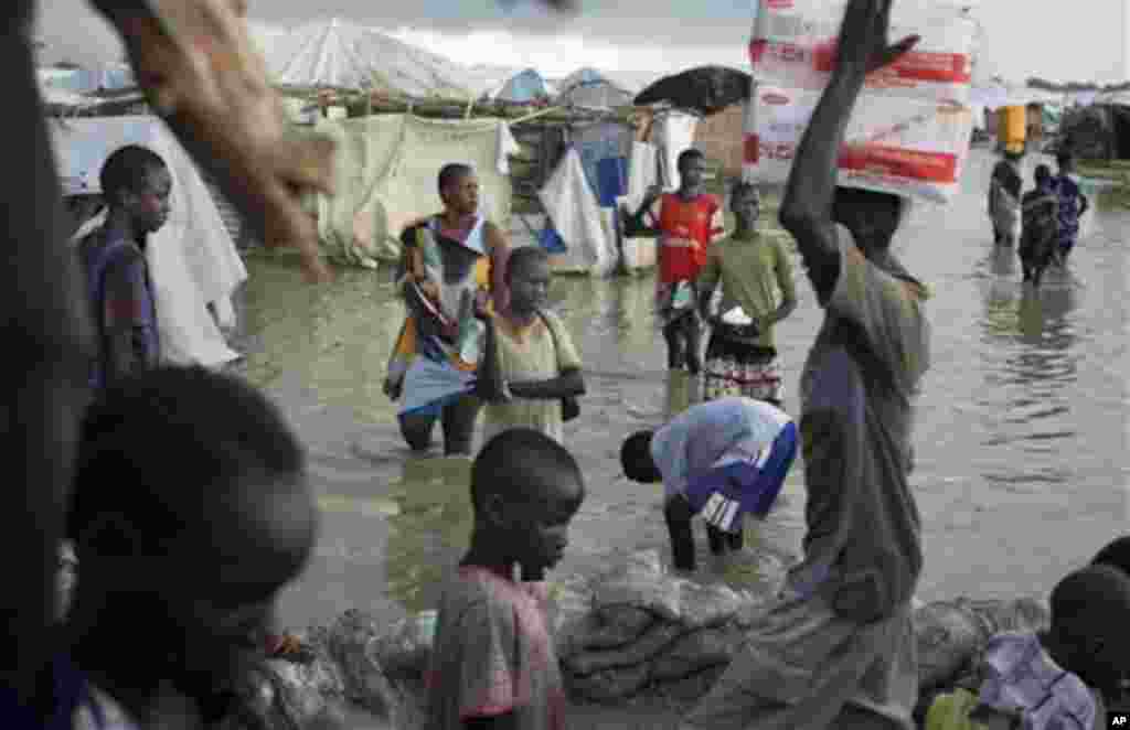 Des déplacés Sud Soudanais marchent dans un marécage d&rsquo;une eau boueuse près de la Mission Onusienne au Sud Soudan (UNMISS) au village de Bentiu, au Sud Soudan. 