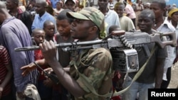 A M-23 rebel fighter walks with his rifle as they withdraw from Goma, December 1, 2012. 