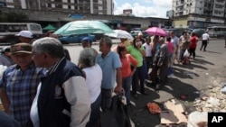 El gobierno del presidente Maduro asegura que las colas en los comercios son parte de una campaña en su contra.