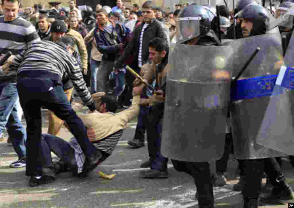 A plainclothes policeman hits a protester during a demonstration in Cairo January 28, 2011. Police and demonstrators fought running battles on the streets of Cairo on Friday in a fourth day of unprecedented protests by tens of thousands of Egyptians deman