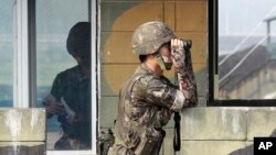 Seorang serdadu AD Korsel dengan teropong di titik pemeriksaan militer di Paviliun Imjingak dekat perbatasan dengan Korea Utara, Korea Selatan, Minggu, 13 Juli 2014 (foto: AP Photo/Ahn Young-joon)