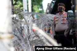 Seorang petugas polisi berjaga di luar gedung Pengadilan Negeri Jakarta Timur saat persidangan ulama Rizieq Shihab digelar di Jakarta, pada 27 Mei 2021. (Foto: Reuters/Ajeng Dinar Ulfiana)