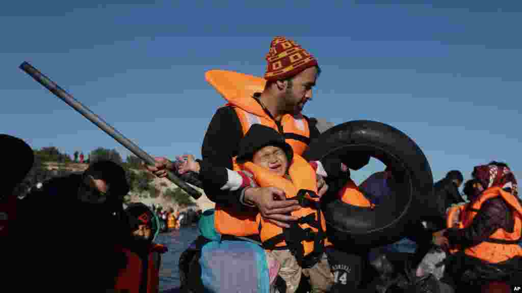 Un enfant porté par un adulte pleure lors d&rsquo;une traversée des migrants en canot à l&#39;île grecque de Chios, en Turquie, 4 novembre 2015.