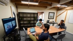 RunX CEO Ankur Dahiya, center, takes part in a video meeting with employees JD Palomino, top left, and Nitin Aggarwal, right, at a temporary office in San Francisco, Friday, Aug. 27, 2021. Technology companies like RunX that led the move into remote work early as the pandemic started, are facing a new difficulty as it calms down: how, when and even if they should bring their employees back to offices that have been made for teamwork. (AP Photo/Eric Risberg)