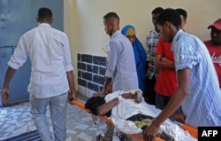 Somalis help a wounded civilian at a hospital following a mortar attack in Mogadishu, Feb. 25, 2016, following a mortar attack near Somalia's presidential palace that killed four people and injured several others.