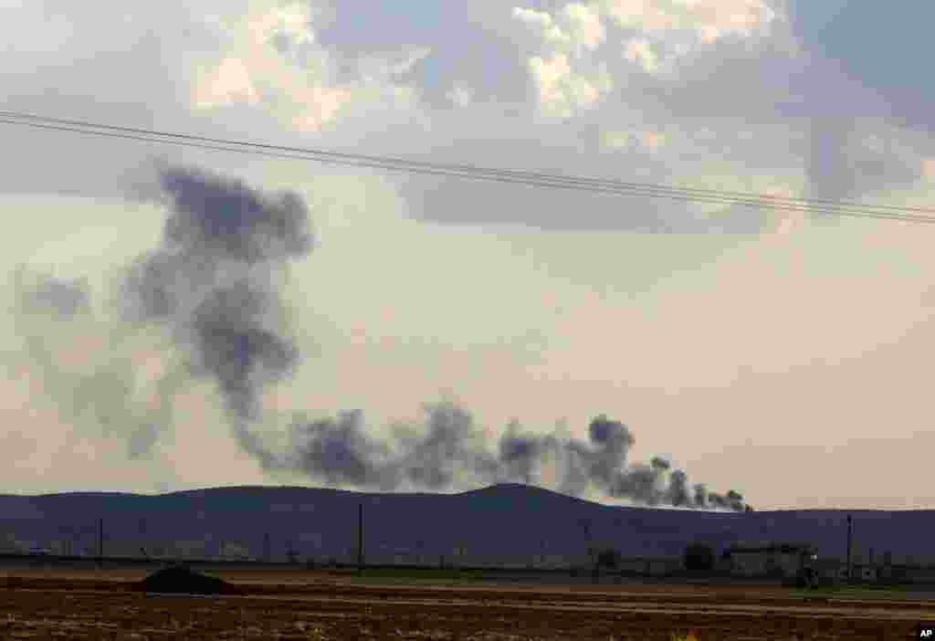 Black smoke from the battle between the Islamic State and Kurdish militants on a hillside just over the border as seen from Abdullah Ocalan, near Suruc, Turkey, Sept. 25, 2014. 