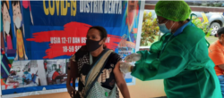 Warga Kampung Demta, Jayapura, Papua, hari Minggu (11/7) divaksinasi oleh tim kesehatan Polsek Demta, Polres Jayapura. (Courtesy: Polda Papua)