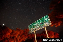 FILE - In this July 22, 2019 file photo, a sign advertises state route 375 as the Extraterrestrial Highway, in Crystal Springs, Nevada, on the way to Nevada Test and Training Range near Area 51.