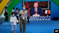 一名女子带着孩子走过北京一处宣传习近平的电子屏幕广告。（2021年9月5日）