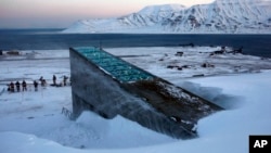 FILE - Snow blows off the Svalbard Global Seed Vault before being inaugurated at sunrise, Tuesday, Feb. 26, 2008. The "doomsday" seed vault built to protect millions of food crops from climate change, wars and natural disasters opened Tuesday deep within an Arctic mountain in the remote Norwegian archipelago of Svalbard. (AP Photo/John McConnico)
