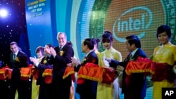 In this file photo, Intel's Paul Otellini, center, and Vietnam's official Le Thanh Hai, fourth right, at open the assembly and test facility of Intel's chipset products at Saigon High Tech Park, October 29, 2010. (AP Photo/Le Quang Nhat)