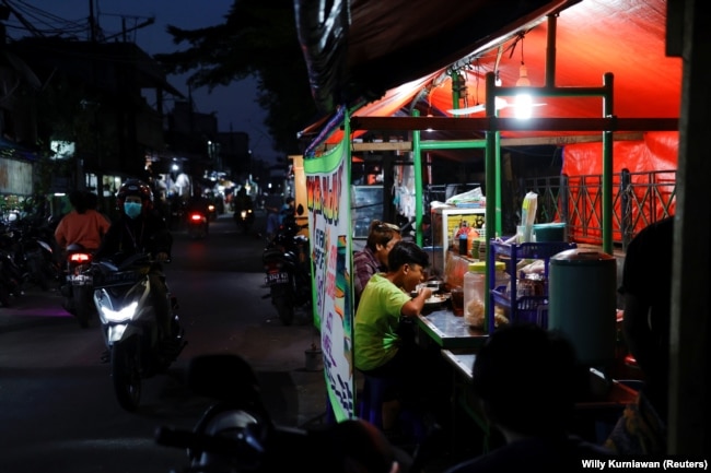 Orang-orang makan malam di tenda jajanan kaki lima saat pelonggaran PPKM di tengah pandemi COVID-19, di Jakarta, 28 Juli 2021. (Foto: REUTERS/Willy Kurniawan)