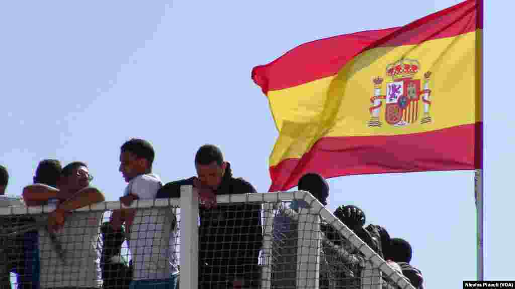 Para migran menunggu turun dari kapal &ldquo;Rio Segura&rdquo; di Pozzallo, Sisilia, Italia.