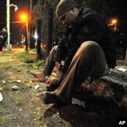 Illegal immigrant cleans his shoes in the square after crossing the border with Turkey in Nea Vissa, northeastern Greece, 480 kilometers east of Thessaloniki (File Photo)