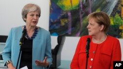 German Chancellor Angela Merkel, right, and British Prime Minister Theresa May give statements prior to a meeting in the chancellery in Berlin, Germany, July 5, 2018. 