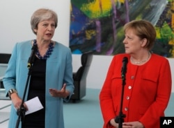 FILE - German Chancellor Angela Merkel, right, and British Prime Minister Theresa May give statements prior to a meeting in the chancellery in Berlin, Germany, July 5, 2018.
