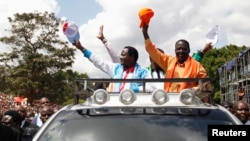 Raila Odinga (R) na mgombea wake mwenza Kalonzo Musyoka wakiwasili viwanja vya Uhuru Park kwa mkutano wa pamoja wa kisiasa 