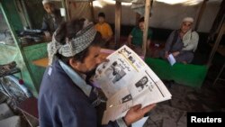 An Afghan man reads a newspaper at a tea shop in Kabul in this May 3, 2011, file photo.