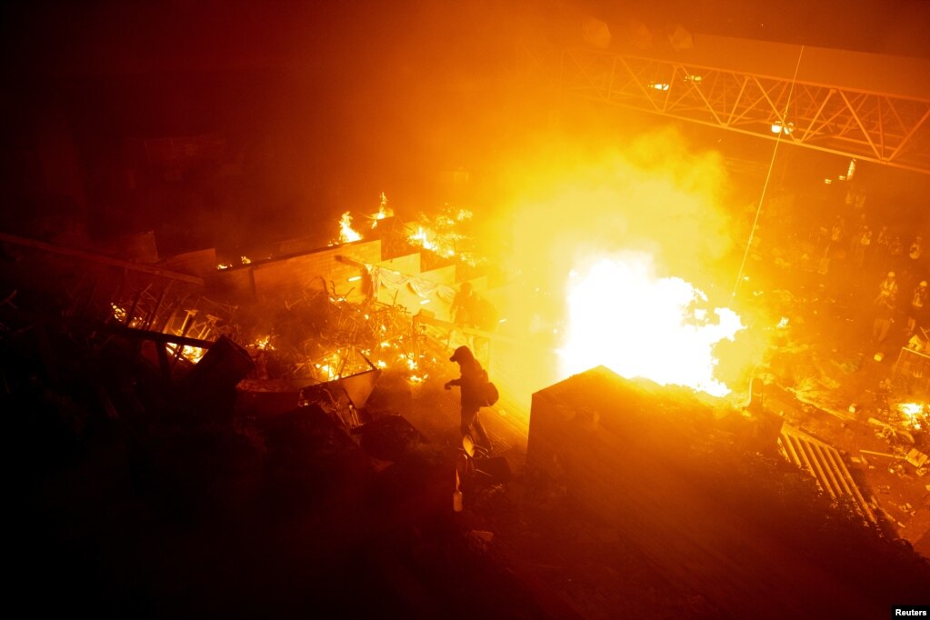 香港理工大学的抗议者站在燃烧的大火旁。（2019年11月18日）(photo:VOA)